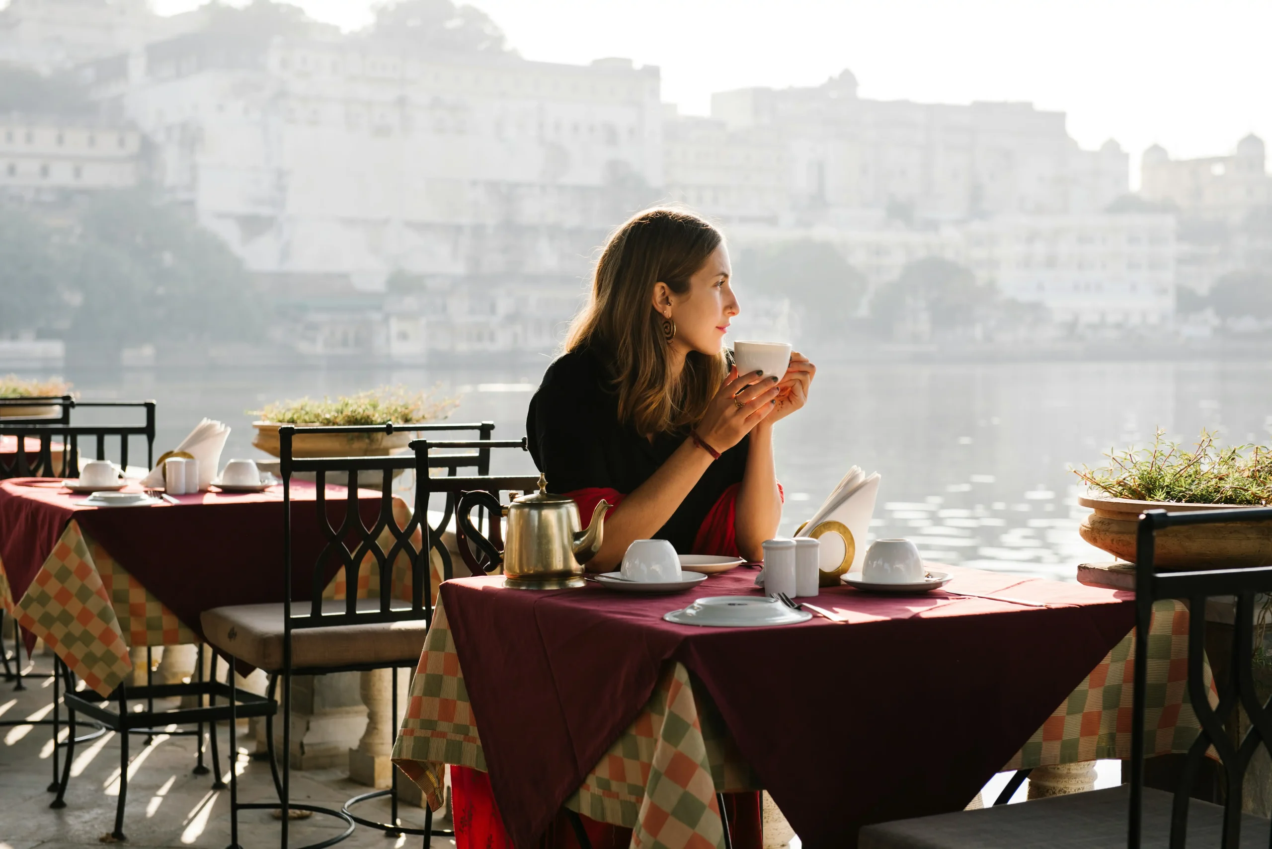 a woman sitting at a table with a cup of coffee